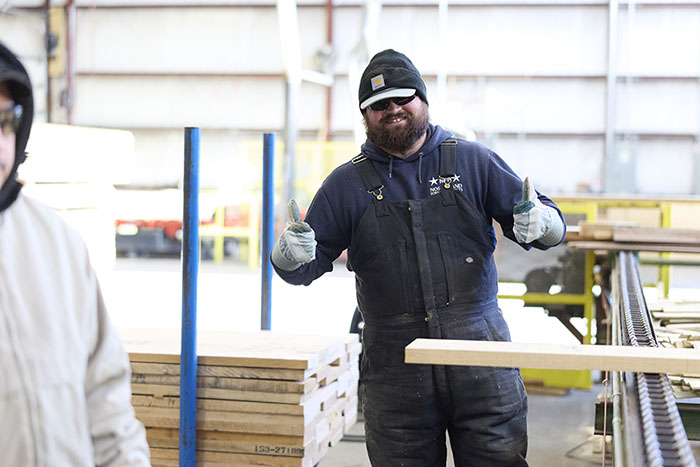 a man giving the thumbs up sign over a board on a table