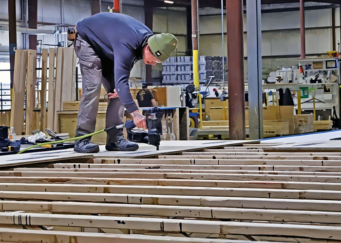 a man nailing a floorboard onto boards