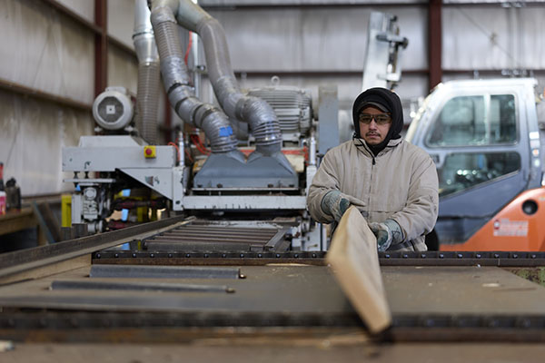 a man cutting a piece of wood on a table