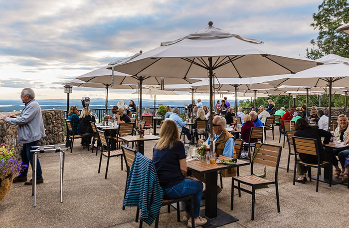 an outdoor patio with people eating at tables under umbrellas