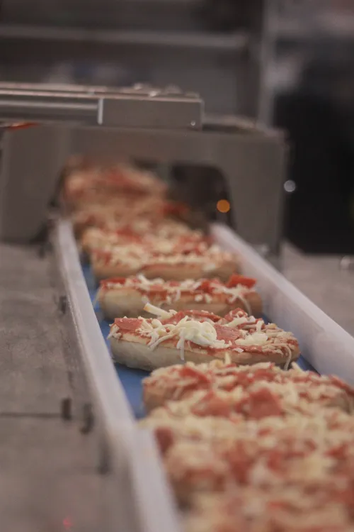 Pizza lined up ready to be distributed