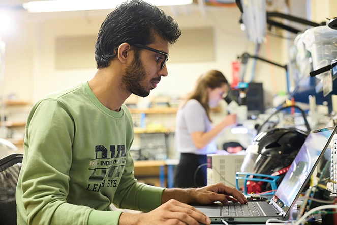 A man working on a laptop in a lab