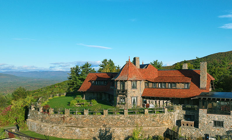 an aerial view of a large stone building with set high in the mountains.