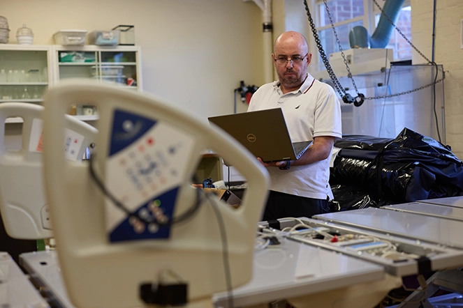 A man working on a computer in a hospital room