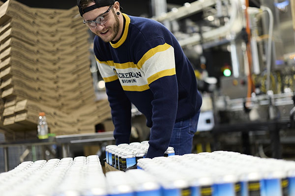 a man moving cases of beer cans