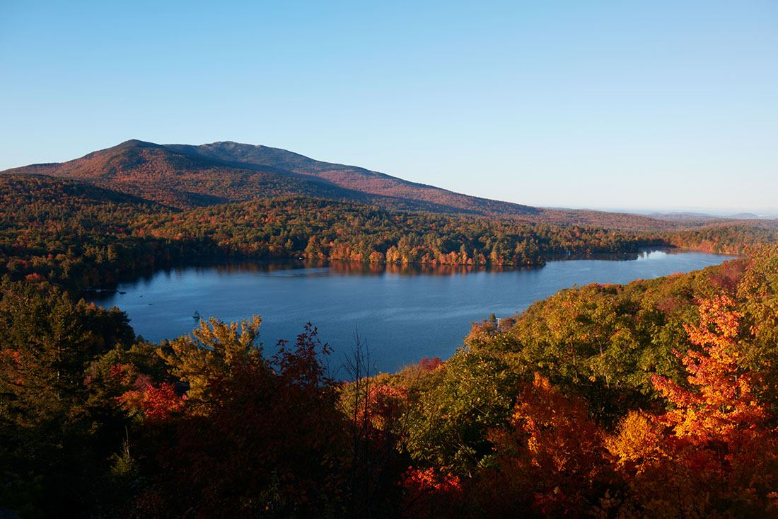 a view of a mountain and lake in fall color