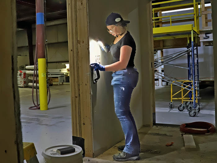 a woman working on a construction project inside a warehouse