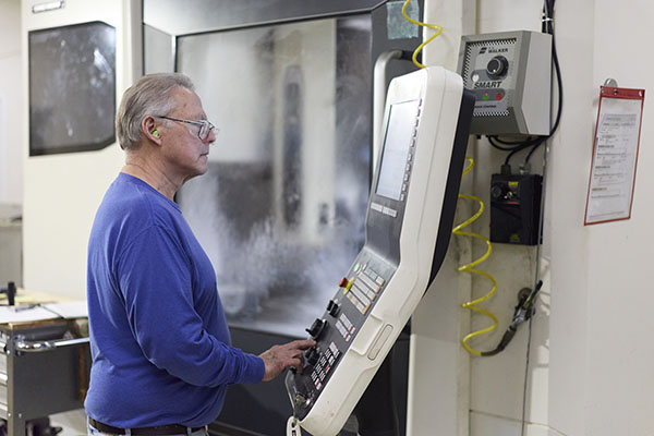 a man working at a screen in an Optics plant.