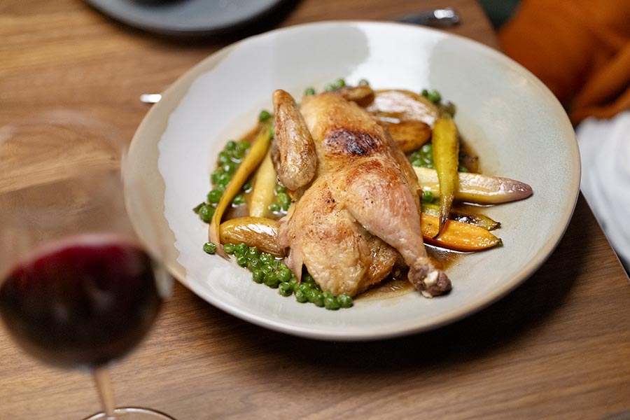 a plate of food with chicken, peas and vegetables.