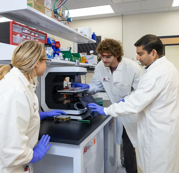 Scientists in a lab looking through a microscope