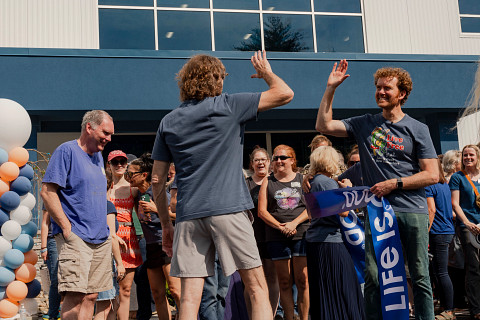 People high fiving outside a Life is Good
