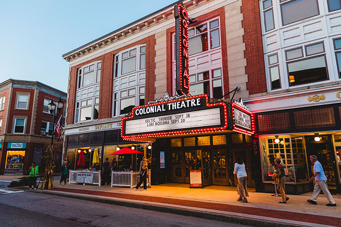 the outside of a theater, with a marquee stating "Colonial Theatre"
