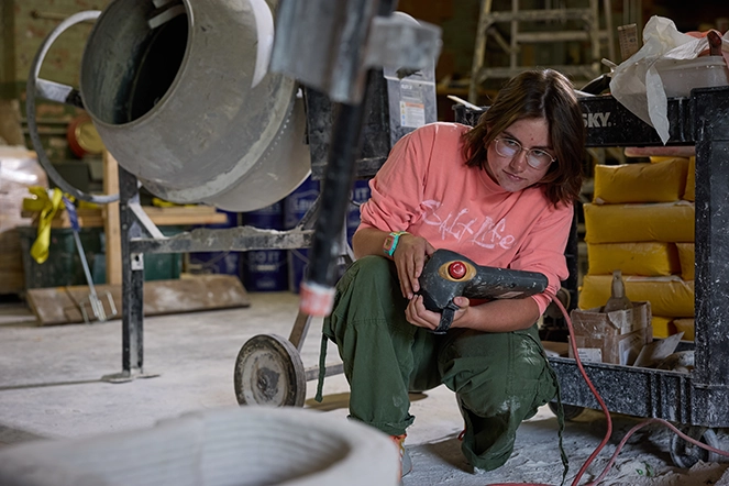 A woman operating machinery in a warehouse