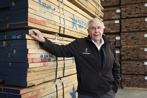 a man standing by a wall of boards