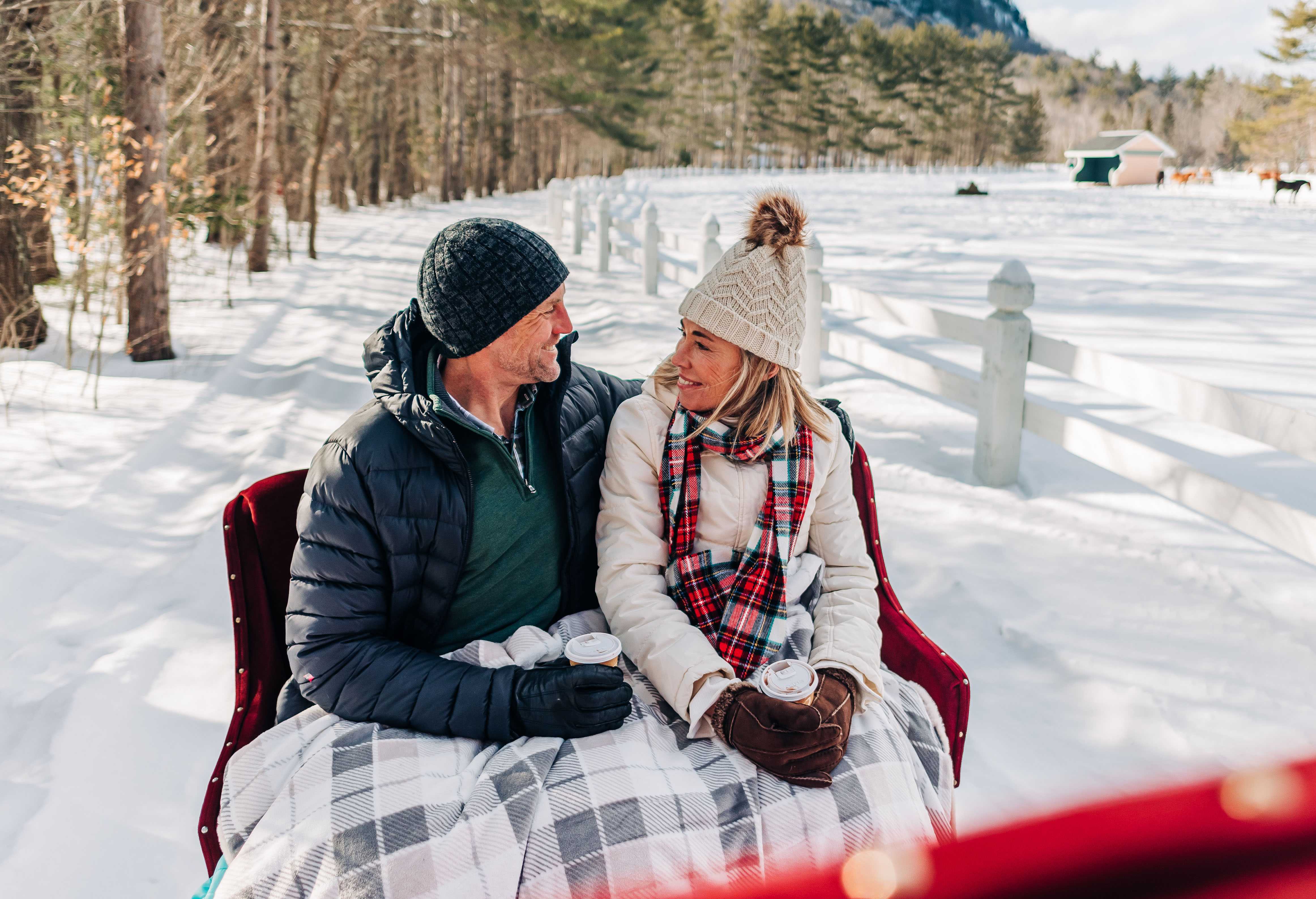 a couple in a horse drawn wagon with cups of coffee