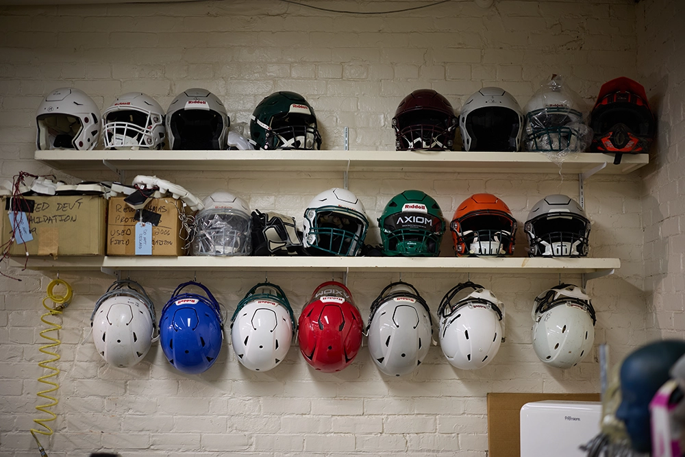 Hockey helmets hanging on hooks on a wall