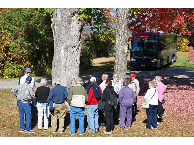 Maple tours in the fall are a big hit. Here the tour learns how to tap a tree.
