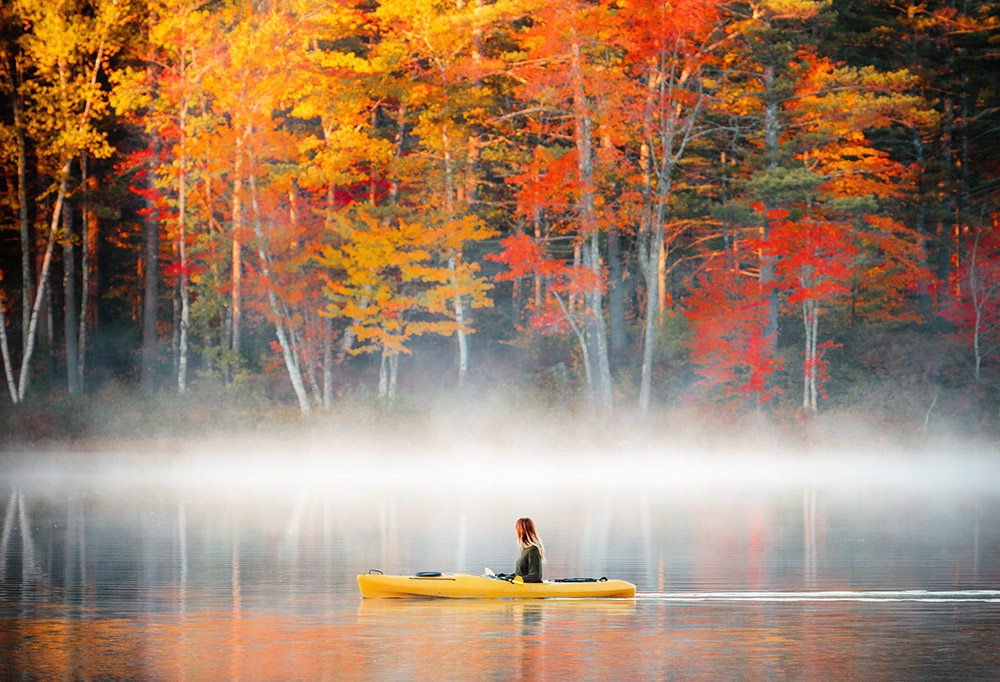a kayaker in the mist in the fall