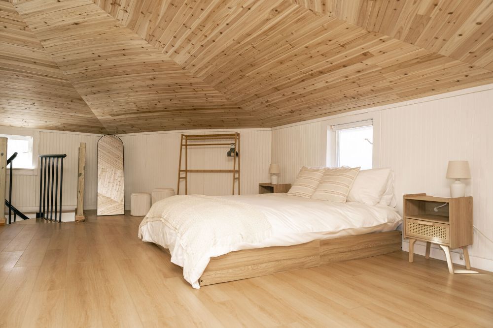 Peaceful loft bedroom with warm wood ceilings