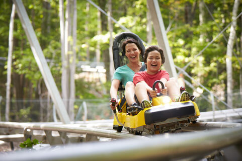 a mother and son on a mountain coaster ride