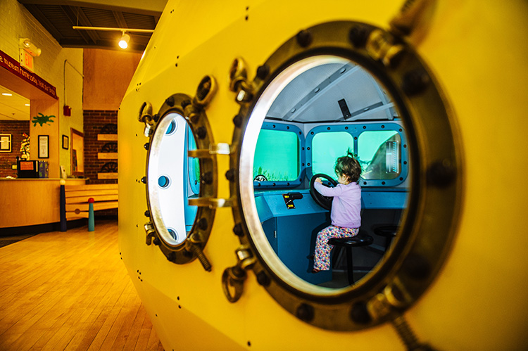 A family favorite exhibit at the Children's Museum of New Hampshire is the Yellow Submarine, which kids can "drive" around a virtual ocean! Photo courtesy of taraphotography.com