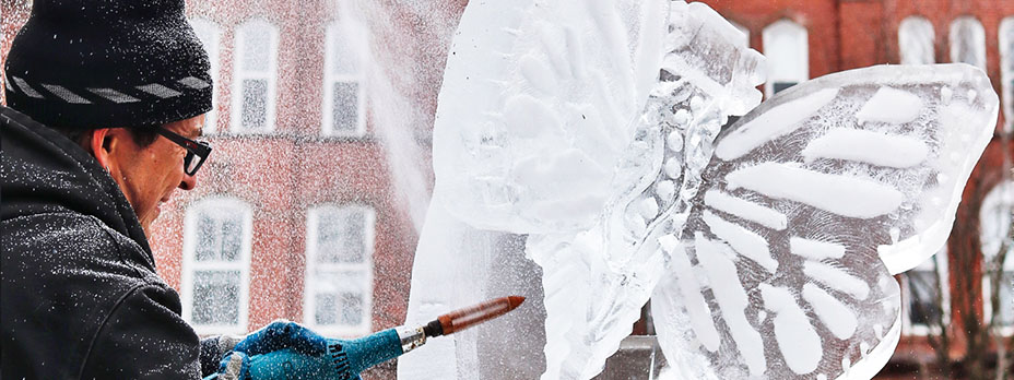 a man carving a butterfly ice sculpture